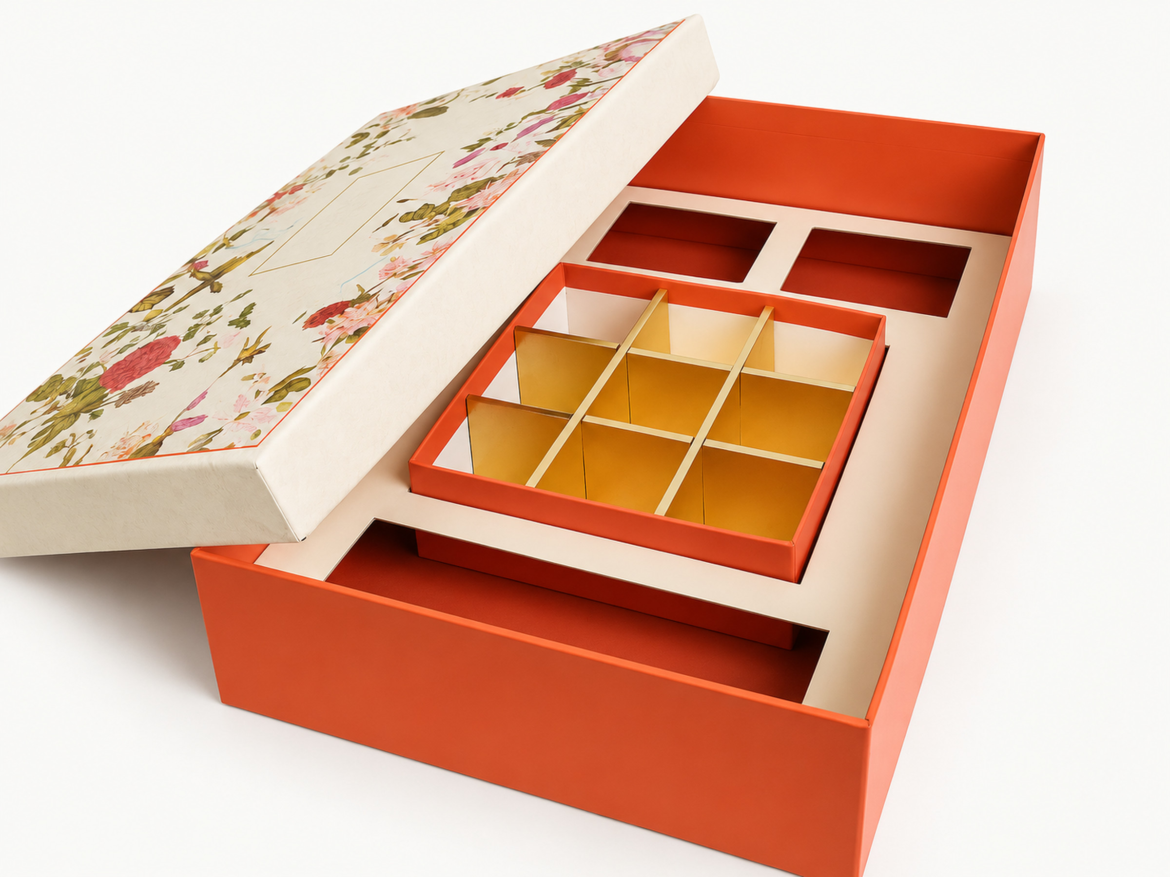 Open orange hamper box with an ivory floral lid, a central nine-section tray and surrounding fitted compartments.