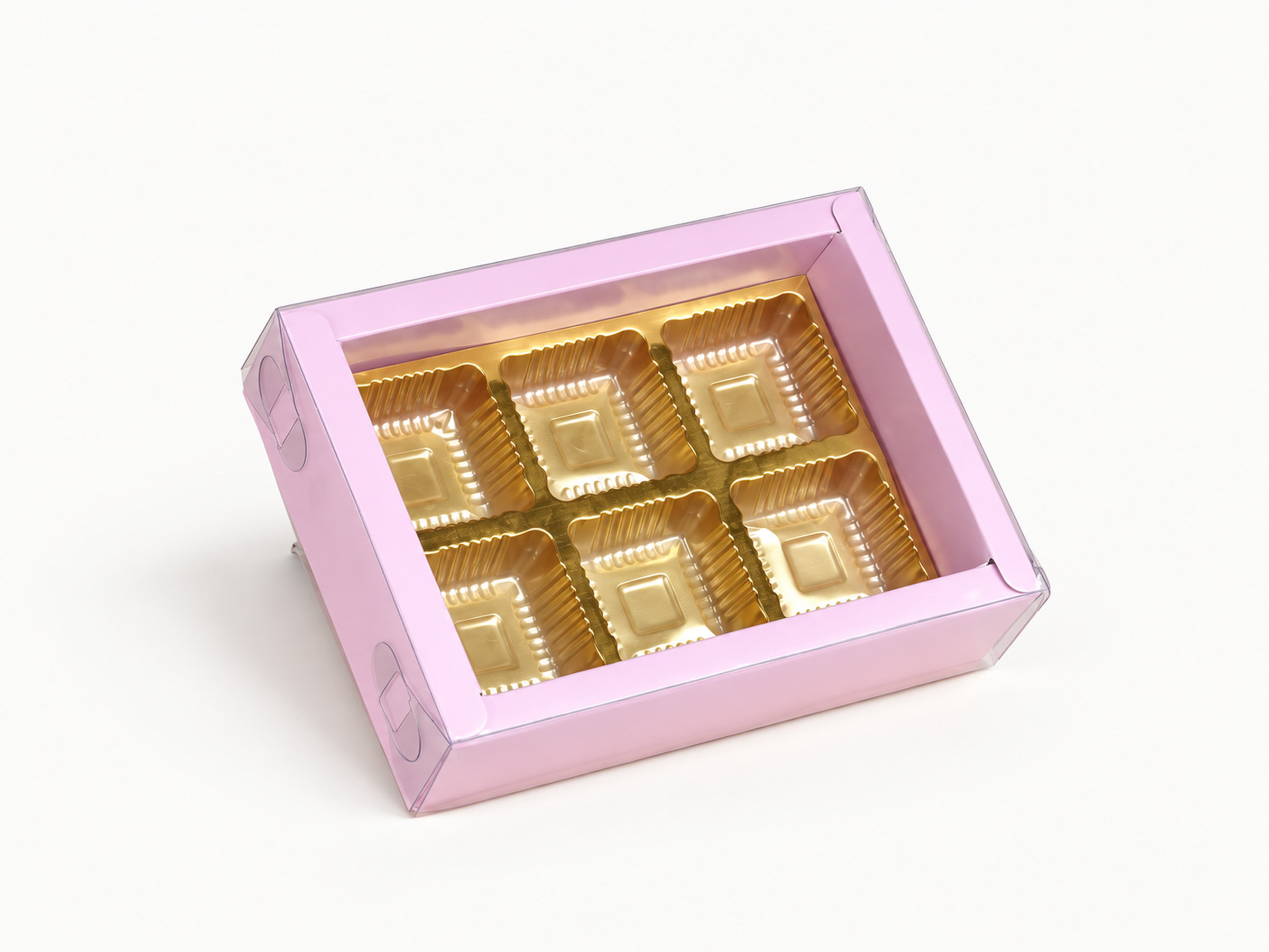 Pastel pink chocolate box with six gold-coloured insert cavities beneath a clear lid.