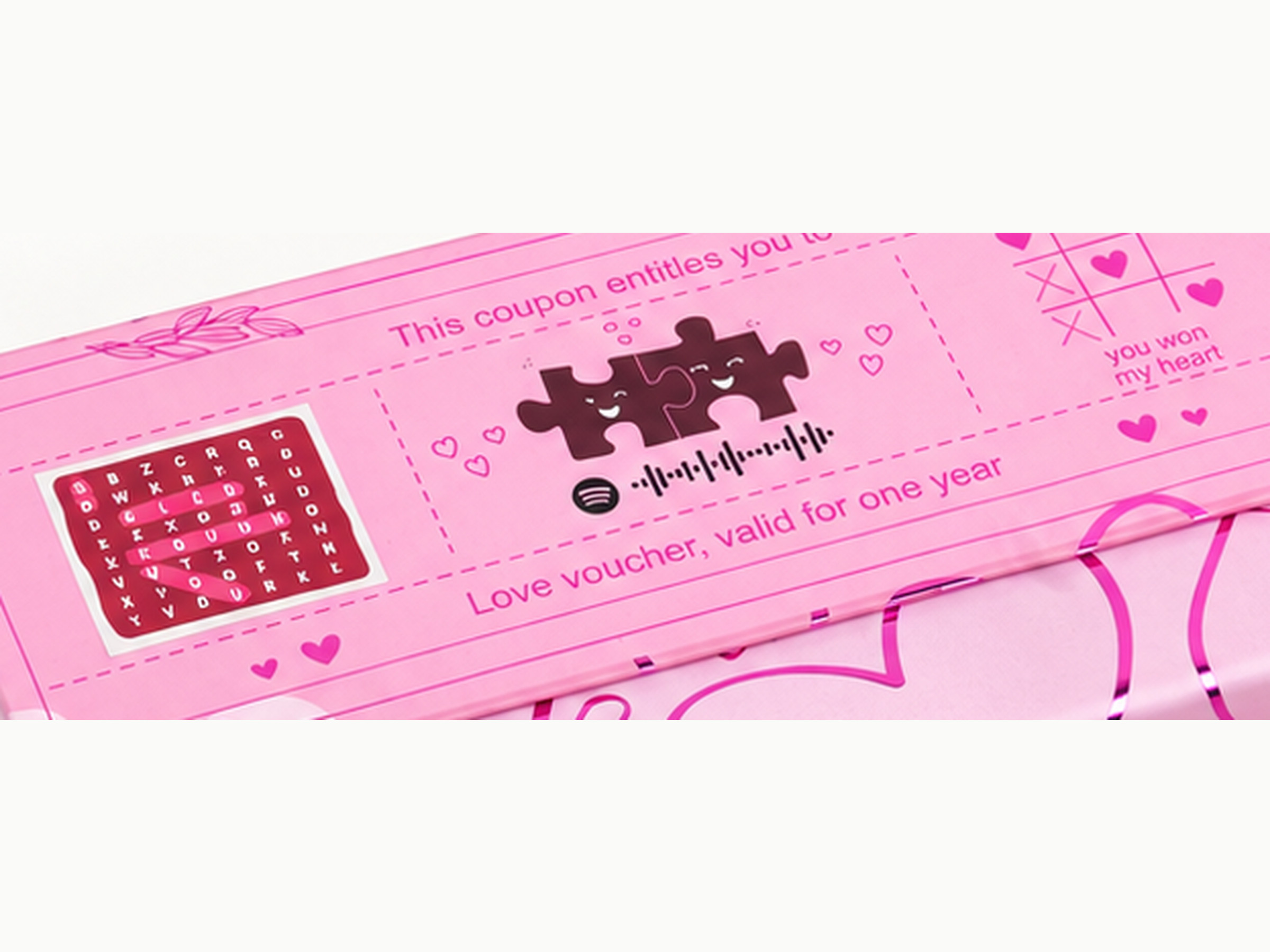 Close-up of the pink Love Notes gift box lid showing printed hearts and love-note artwork, shown in a square detail crop.