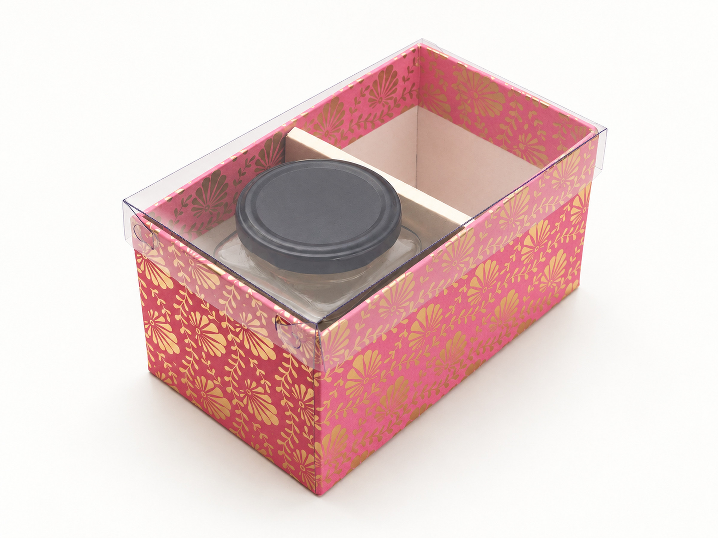 Pink floral jar hamper box under a clear lid, with a gold divider and one black-lidded jar visible inside.