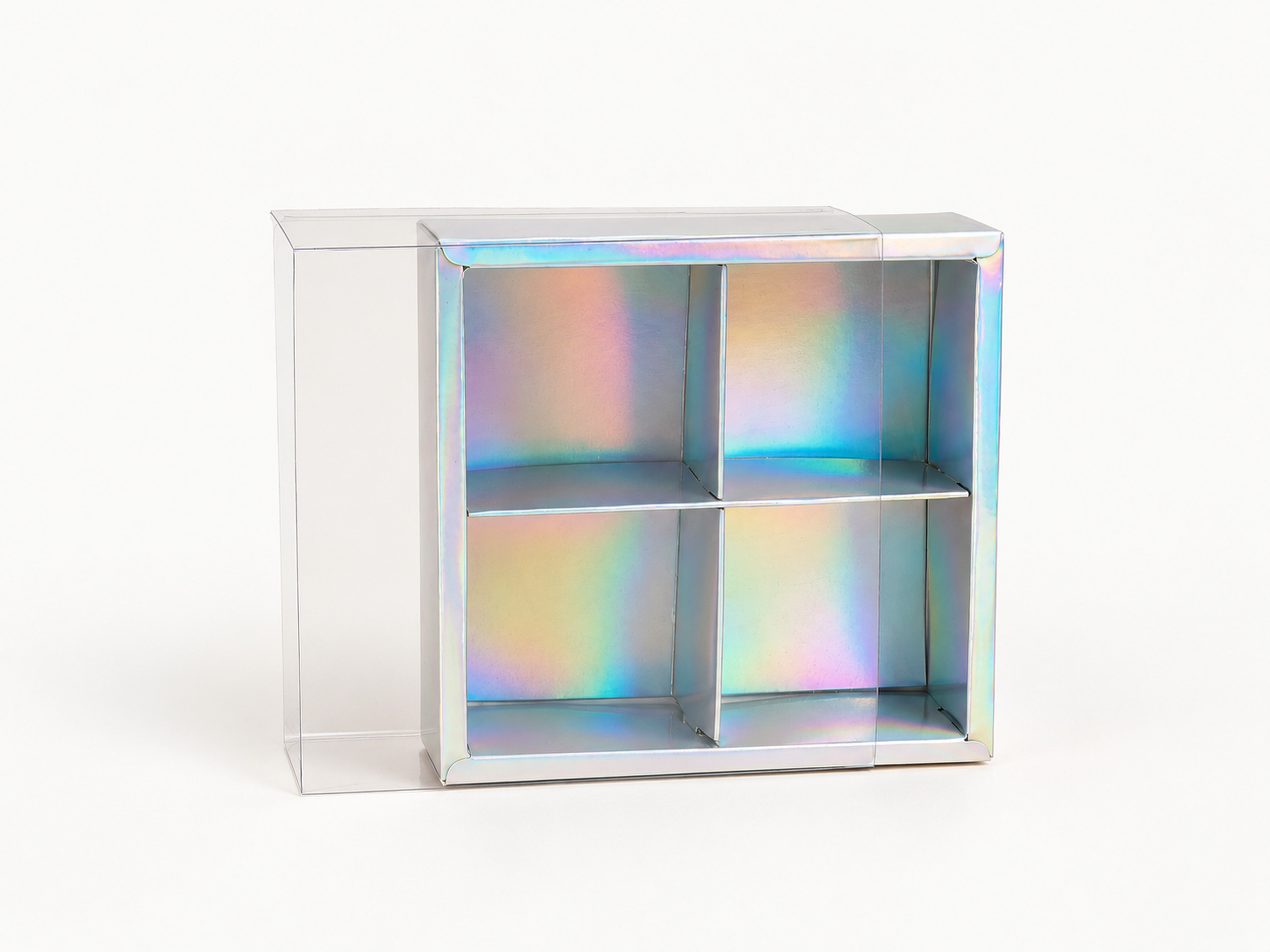 Iridescent four-compartment gift box shown upright with its clear cover partly slid to the left.