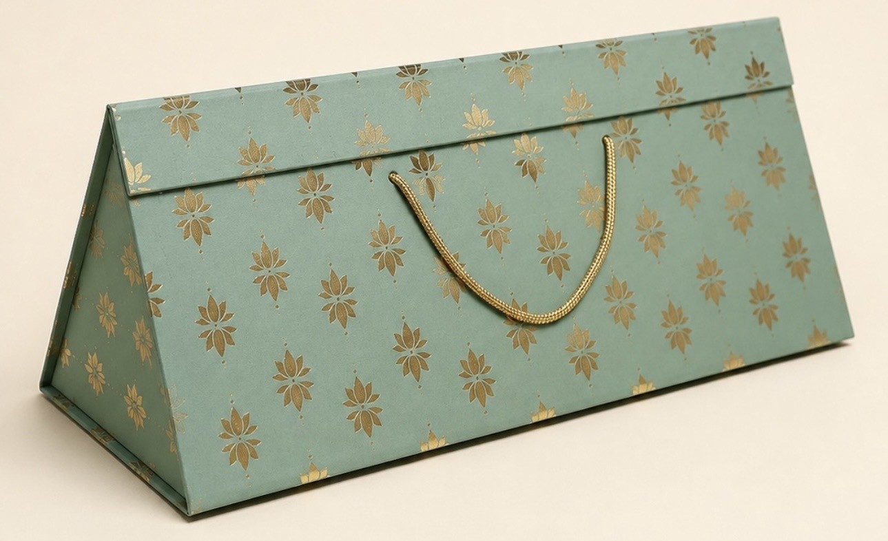 Sage green triangular gift box with gold-coloured lotus motifs and a gold rope handle.